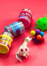 three colourful jars of cloud putty and three fidget toys on a pink background