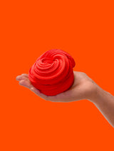 Red background with a hand and arm coming in from the side holding a swirl of red sensory putty