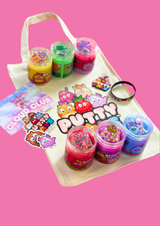 Six jars of colourful cloud putty on a tote bag with the Putty Pals logo on it. Character stickers, keyring and a bracelet are all laid on the bag.