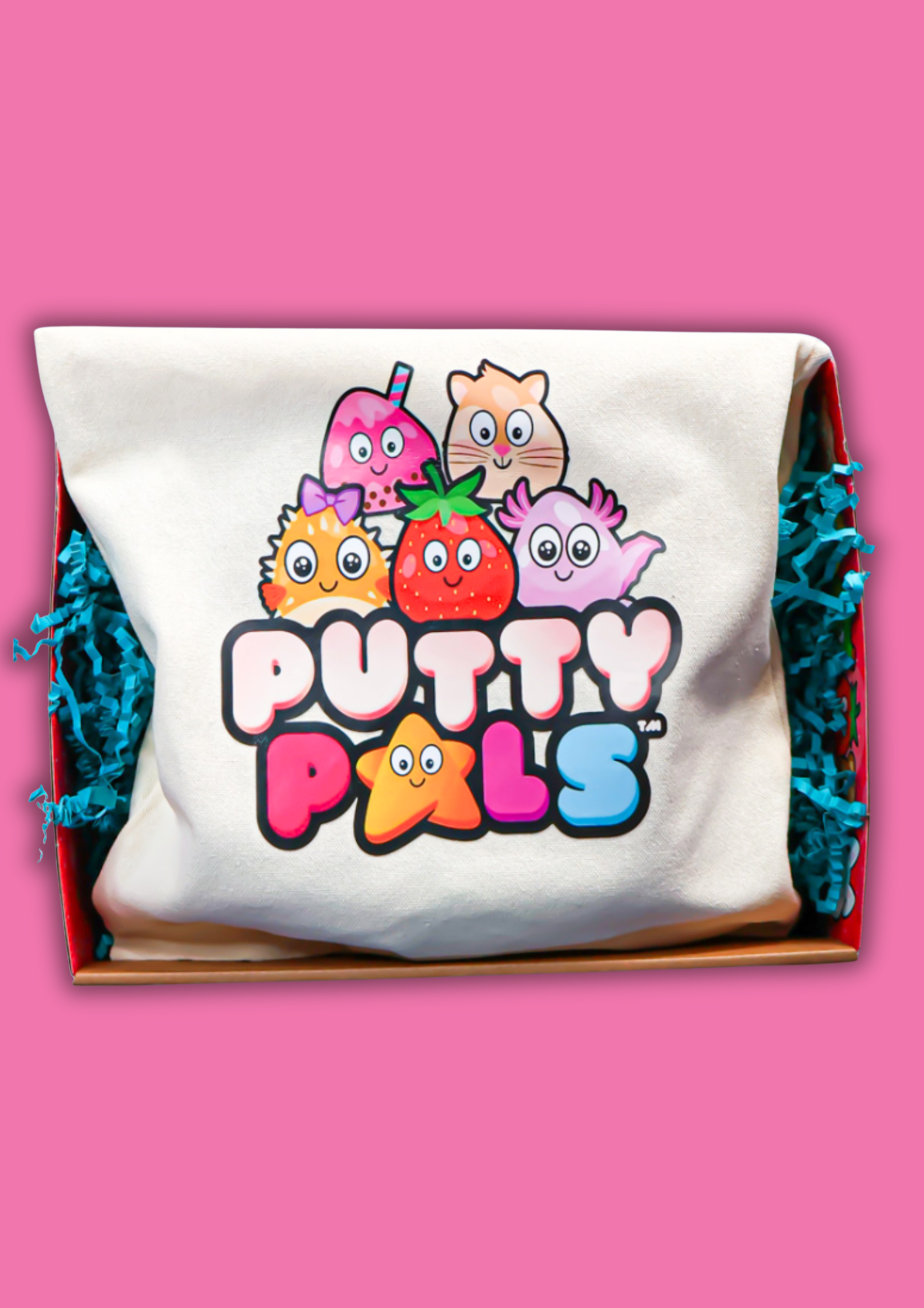A tote bag with the Putty Pals logo on inside a box with blue shred all on a pink background
