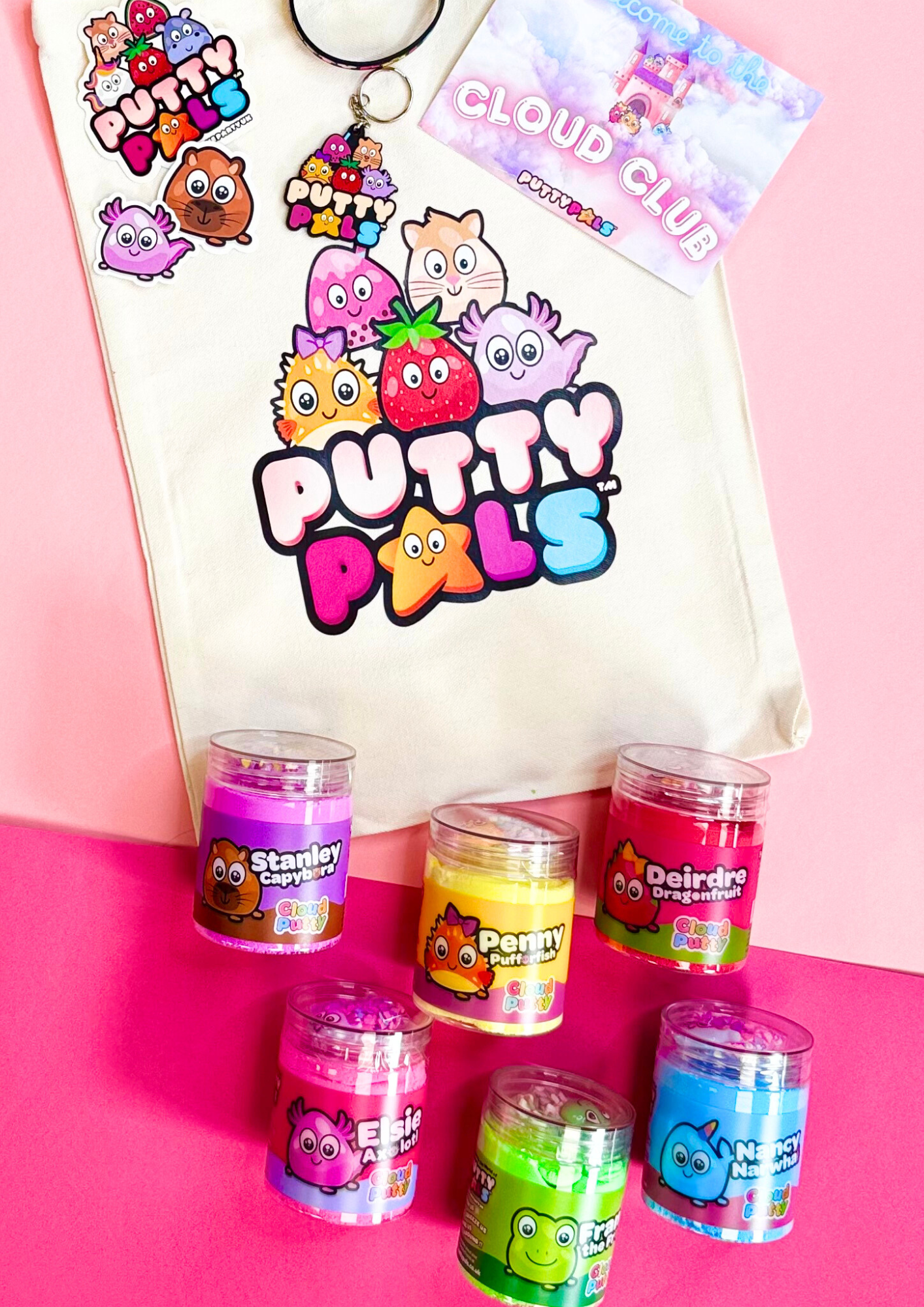 A tote bag with the Putty Pals logo on with colourful jars of could putty at the bottom, stickers and a keyring are also laid on the bag. 
