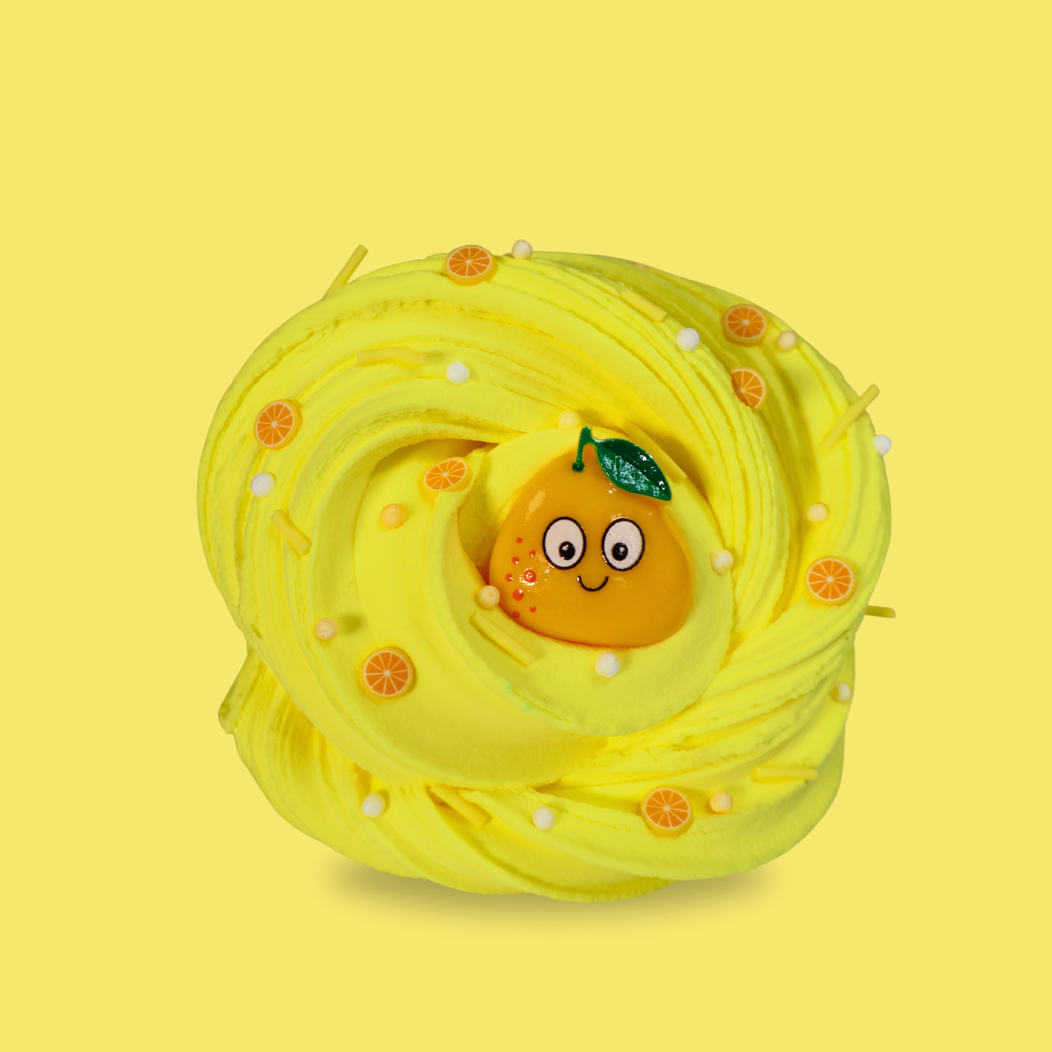 yellow swirled sensory putty decorated with small lemon slices, yellow sprinkles and white floam balls. A smiling cartoon lemon charm is in the middle