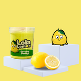 Yellow sensory putty on a plinth, collectable charm Lola Lemon to the side, with some lemon showcasing the scent