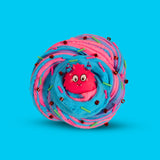 A swirl of pink and blue sensory putty, decorated with clay sprinkles, red bingsu beads and a cartoon monster in the centre 