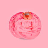 A pink swirled sensory putty decorated with pink bingsu beads and clay sprinkles, there is a large cartoon pig charm at the top of the putty