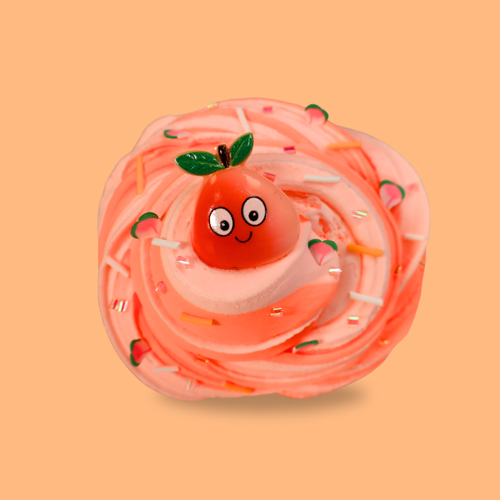 a duo swirl of light peach and dark peach sensory putty, decorated with iridescent bingsu beads, white and orange bingsu beads and clay peach slices. A larger cartoon charm in in the centre of it 