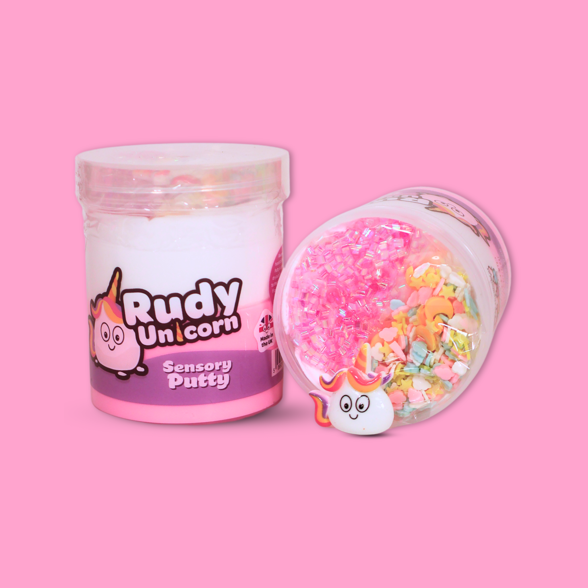 A jar of white and pink sensory putty named Rudy Unicorn, a jar is laid next to ti showing bingsu beads, clay sprinkles and a unicorn charm