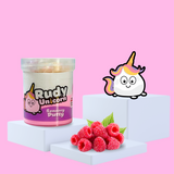 Duo white and pink sensory putty on a plinth, collectable charm Rudy Unicorn to the side, with some raspberries showcasing the scent