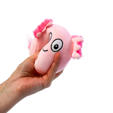 WHite background with a hand coming in from the side that is squishing a pink axolotl sugarball