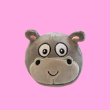 Pink background with a round sugarball plush in the shape of a hippo head with a smiley face